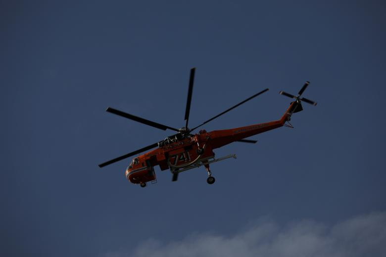 Trực thăng cứu hỏa bay qua một đám cháy ở Kineta, gần thủ đô Athens ngày 23/7.