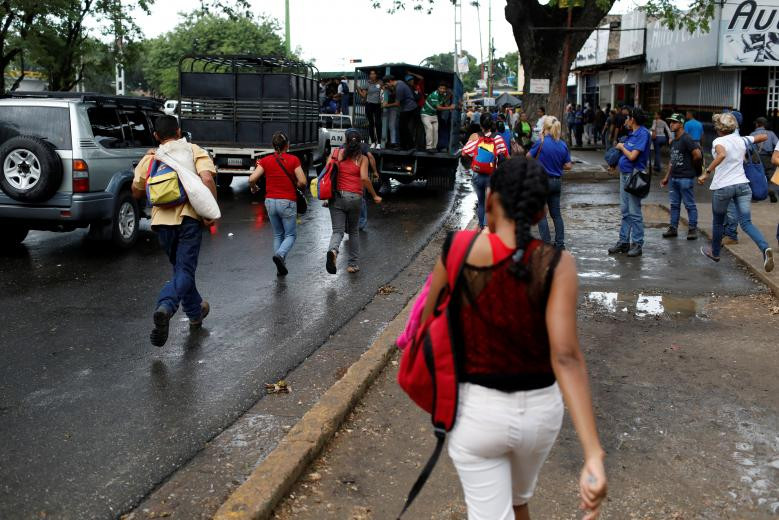 Mọi người đuổi theo một chiếc xe tải chở hàng ở Valencia để không bị lỡ chuyến.