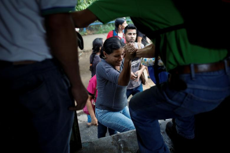 Cảnh tượng vất vả khi lên xe của người dân ở Valencia. “Tôi sợ bị ngã nên phải bám chặt vào chiếc xe tải. Thậm chí tôi từng bị trộm tiền và điện thoại ở trên xe”, hành khách Andreina Leal chia sẻ.