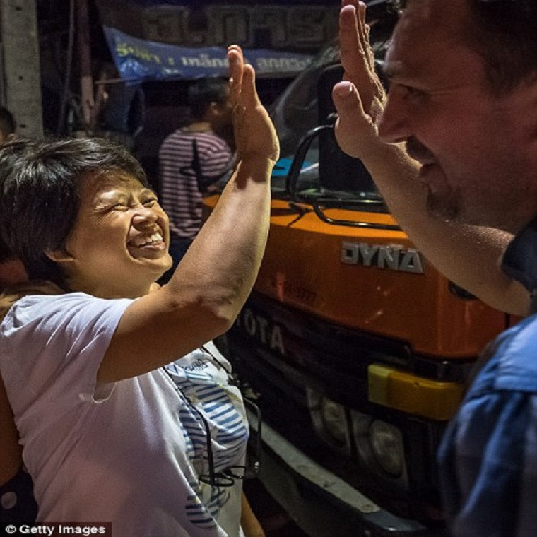 Mọi người đập tay ăn mừng bên ngoài bệnh viện tỉnh Chiang Rai tối 10/7. Ảnh: Getty.