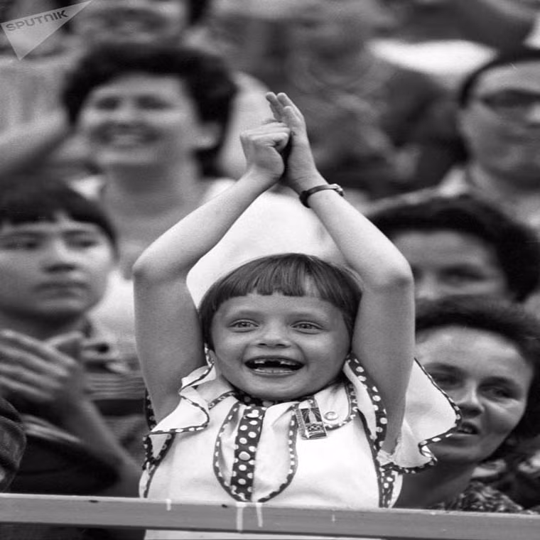 Một em nhỏ đứng lên cổ vũ khi xem trận bóng rổ giữa đội tuyển Liên Xô và Nam Tư tại Olympic Mùa hè năm 1980.