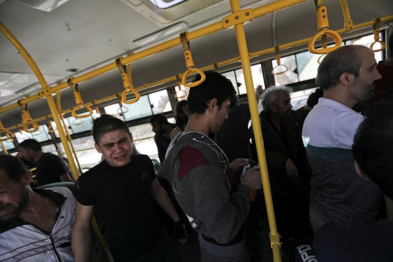 Các tay súng nổi dậy vừa được chính phủ Syria phóng thích khỏi nhà tù lên xe buýt để tới khu El Eis, Aleppo.