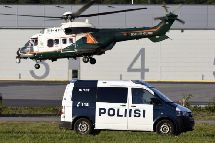 Một xe cảnh sát và trực thăng chờ Tổng thống Trump ở khu vực sân bay quốc tế Helsinki. Ảnh: Reuters.