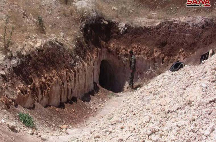 Một binh sĩ Syria đứng trước lối vào hệ thống đường hầm của nhóm phiến quân ở Homs. Ảnh: SANA.