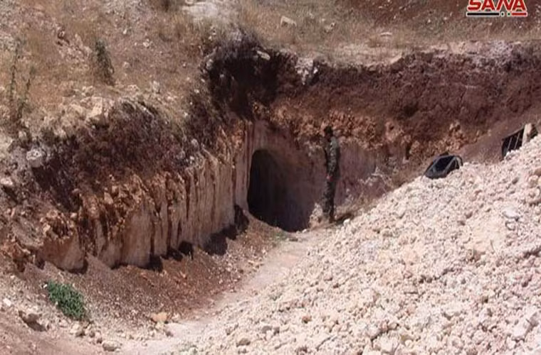 Một binh sĩ Syria đứng trước lối vào hệ thống đường hầm của nhóm phiến quân ở Homs. Ảnh: SANA.