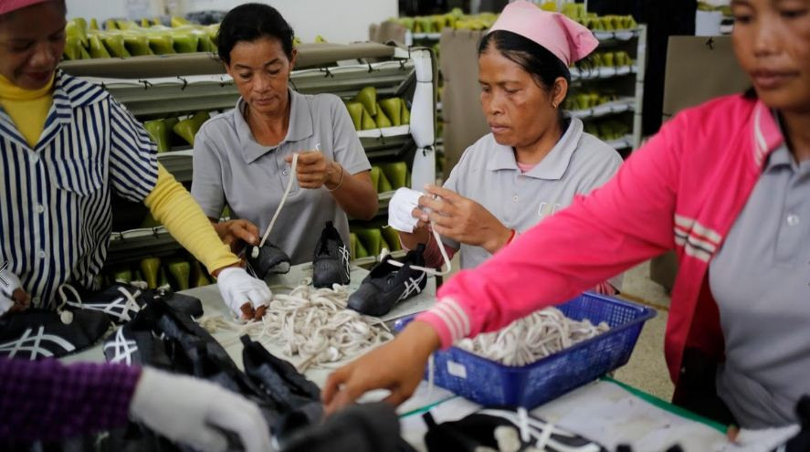 Các nữ công nhân hăng say làm việc theo dây chuyền sản xuất.