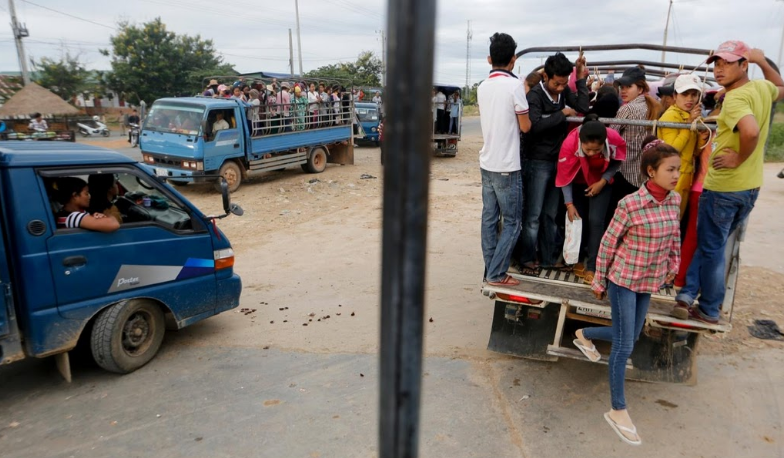 Các công nhân xuống xe khi tới nơi làm việc.