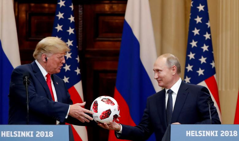 Tổng thống Nga Putin tặng cho ông Trump một quả bóng World Cup trong buổi họp báo. Ảnh: Reuters.