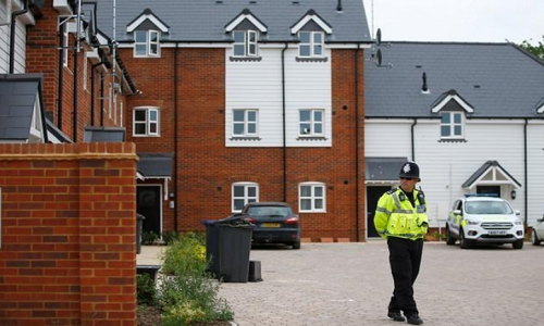 Cảnh sát đứng trước một tòa nhà trên đường Muggleton, khu vực bị phong tỏa sau khi hai công dân Anh được đưa vào bệnh viện. Ảnh: Reuters.