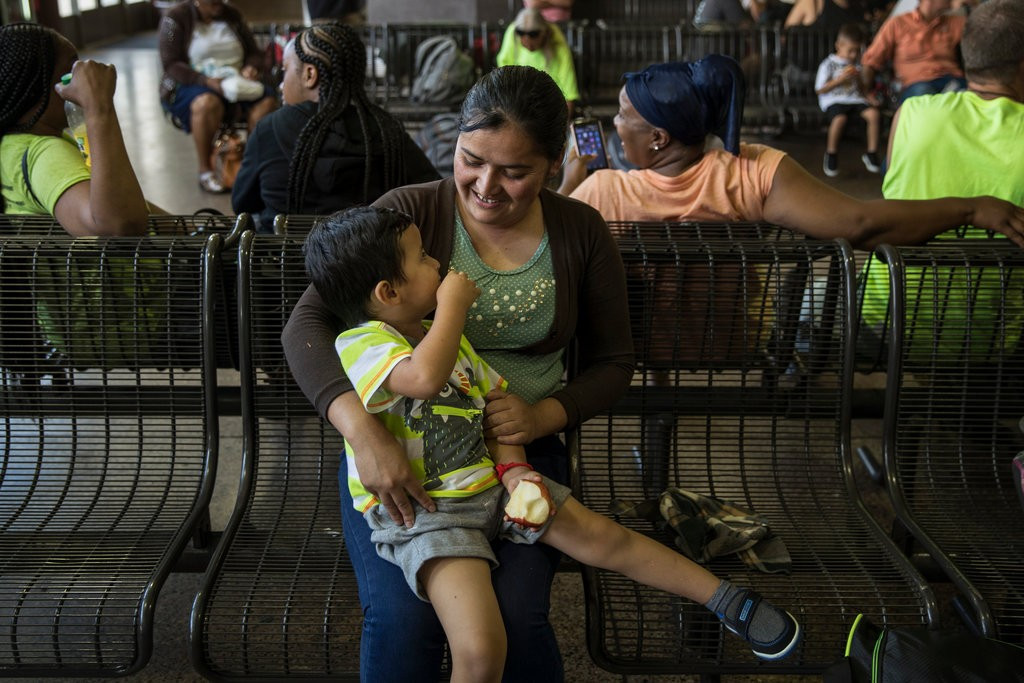 Mirce Alva Lopez, 31 tuổi, và con trai Adan 3 tuổi tại một bến xe buýt ở Phoenix. Hai mẹ con chị được gặp lại nhau hôm 10/7 sau 4 tháng xa cách vì chính sách nhập cư của ông Trump. Ảnh: New York Times.