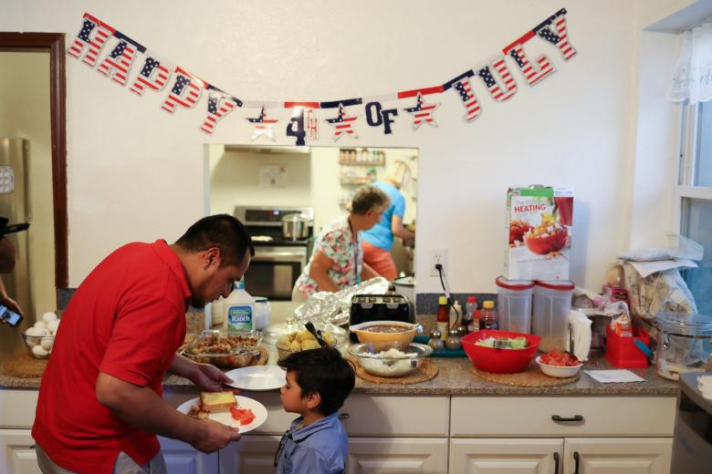 Walter Armando Jimenez Melendez chuẩn bị đồ ăn cho con trai tại trung tâm La Posada Providencia ở San Benito, bang Texas. Ảnh: Reuters.