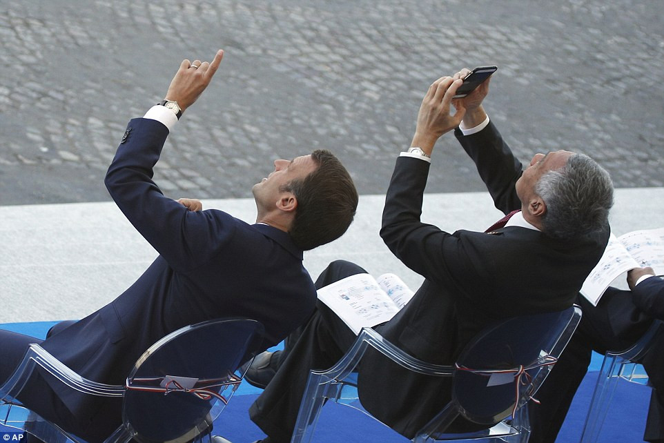 Thủ tướng Singapore Lý Hiển Long lấy điện thoại ghi lại màn trình diễn ấn tượng của những chiếc máy bay Không quân Pháp trên bầu trời Paris. Ảnh: AP.