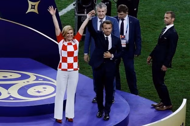 Trước đó, ngày 2/7, Tổng thống Kolinda cũng trực tiếp đến sân cổ vũ cho đội tuyển Croatia trong trận gặp Đan Mạch. Sau trận thắng Đan Mạch, bà đã vào phòng thay đồ để ôm hôn và chúc mừng từng cầu thủ Croatia. Ảnh: Bà Kolinda đứng cạnh Tổng thống Pháp Emmanuel Macron tối 15/7. Ảnh: Twitter.