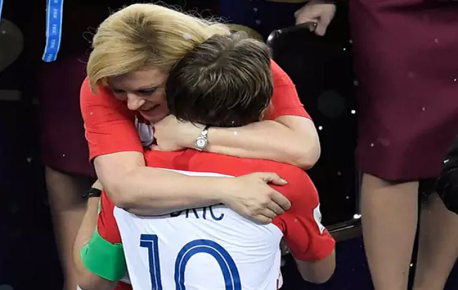 Tại lễ trao huy chương sau khi trận chung kết kết thúc, giữa lúc trời đổ mưa, bà Kolinda chẳng chờ che ô, vẫn đứng ôm và động viên, chúc mừng từng cầu thủ Croatia. Ảnh: Twitter.