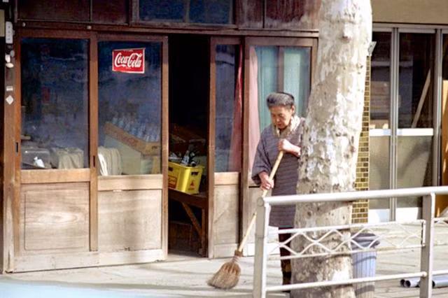 Người phụ nữ lớn tuổi đang quét trước hiên nhà. Ảnh Sina