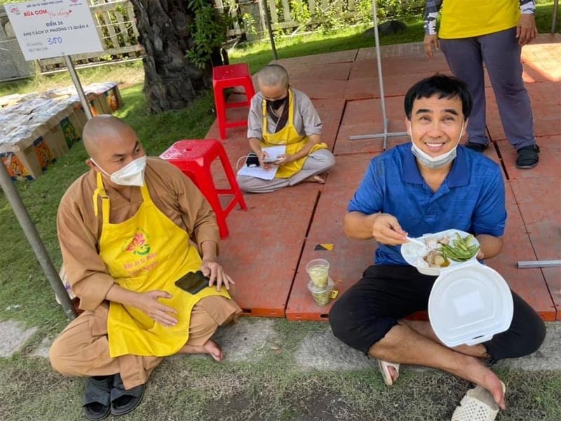 Quyền Linh tham gia các bếp ăn thiện nguyện, đi phát quà từ thiện cho người dân trong từng con hẻm. Có lần đi thiện nguyện, anh ngồi bệt ăn vội bữa cơm. Ảnh: FBNV