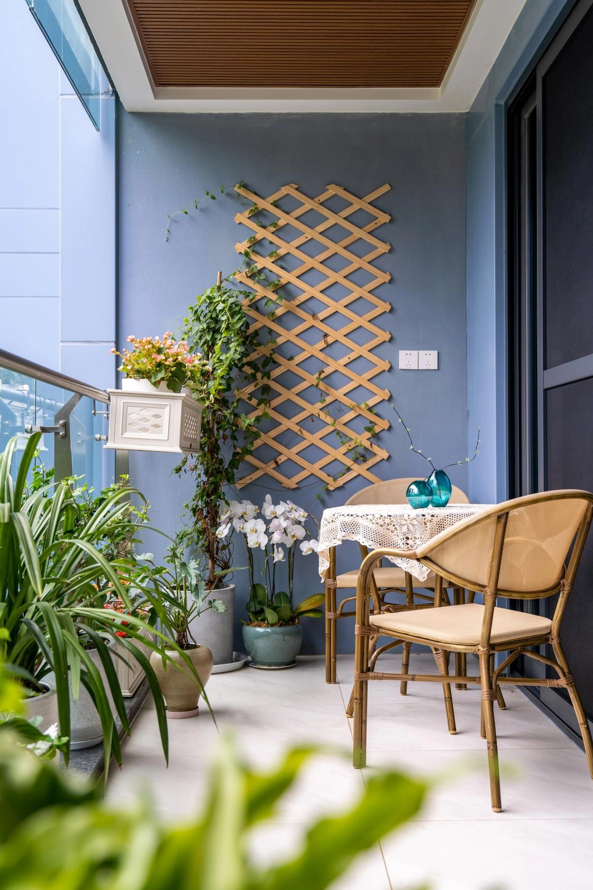 Ban công được sơn đồng nhất màu xanh lam tươi mát, luôn ngập tràn ánh sáng. Đây là một khu vườn nhỏ được chính chủ nhân căn hộ tự tay chăm sóc. Khu vườn ban công có sự xuất hiện của khá nhiều loại cây xanh mang đến bầu không khí dễ chịu, thoải mái khó có được giữa thành phố. Vì thế, ban công cũng là nơi nghỉ ngơi yêu thích của gia chủ.