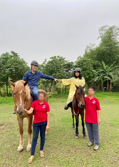 Cặp đôi nắm tay nhau khi ngồi trên yên ngựa.