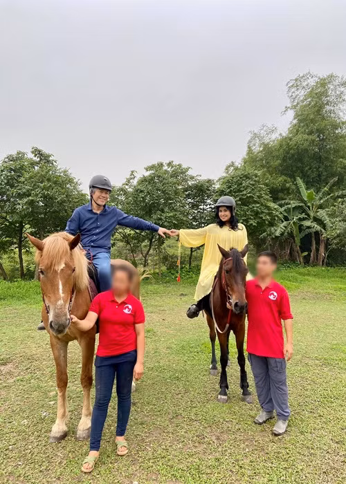 Cặp đôi nắm tay nhau khi ngồi trên yên ngựa.