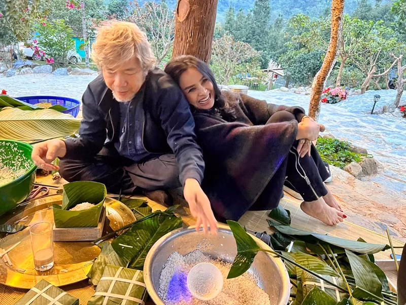 Thanh Lam tựa vào vai bác sĩ Tiến Hùng trong lúc vị bác sĩ này gói bánh chưng.