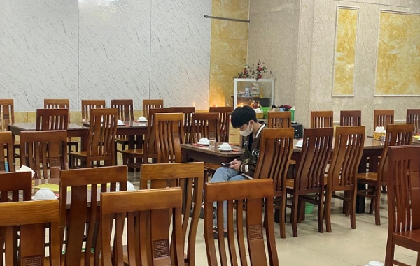 Vắng khách, nhân viên quán bia Hải Hói ngồi lướt điện thoại "giết" thời gian.