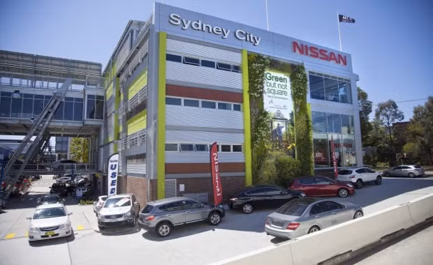 Tấm biển quảng cáo với cây xanh mướt mắt tại một cửa hàng.