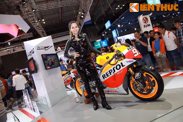 Chiếc xe đua RC213V của Marc Marquez bên người mẫu với bộ suit bó sát, mang phong cách mạnh mẽ.