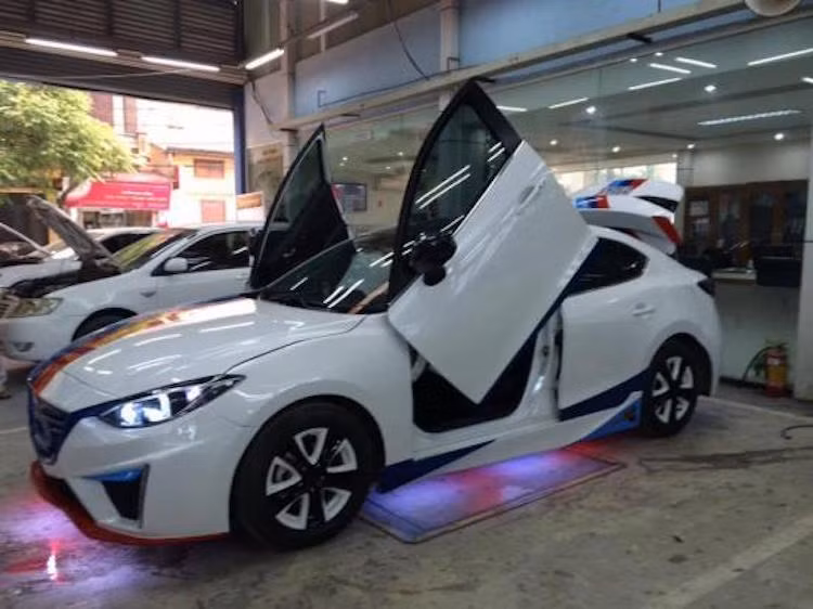 Điểm đặc biệt nhất của chiếc Mazda 3 này đó là cửa trước của chiếc xe đã được chế bản lề thủy lực để có thể mở lật lên như những chiếc Lamborghini hàng đầu. Để có thể chế bản lề, bộ cửa gốc cùng vòm bánh của chiếc xe phải được sửa đổi lại.