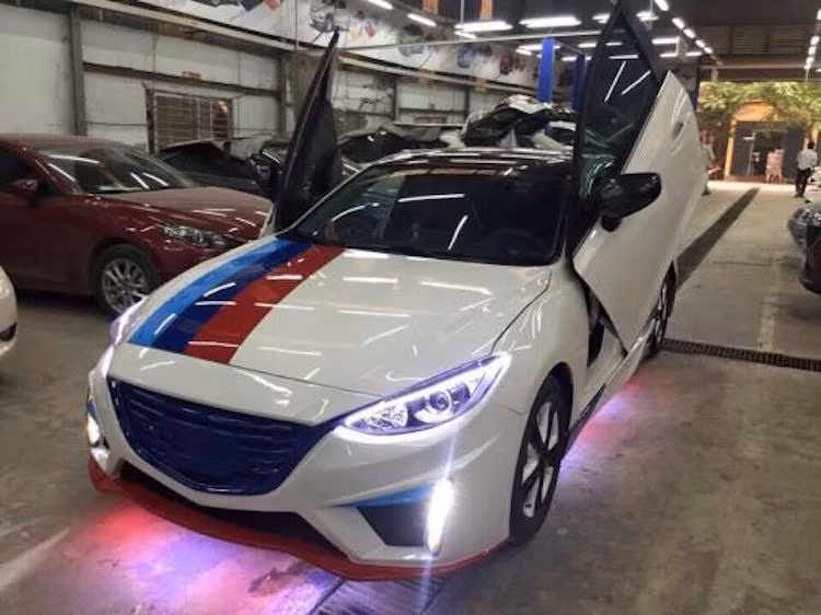 Một điểm đặc biệt không thể không nhắc tới của chiếc xe đó là những vạch kẻ 3 màu xanh da trời, xanh navy và đỏ trên nền sơn trắng theo phong cách BMW M Sport. Dù không liên quan tới Mazda 3 nhưng những đường trang trí này cũng giúp cho chiếc xe bắt mắt hơn.