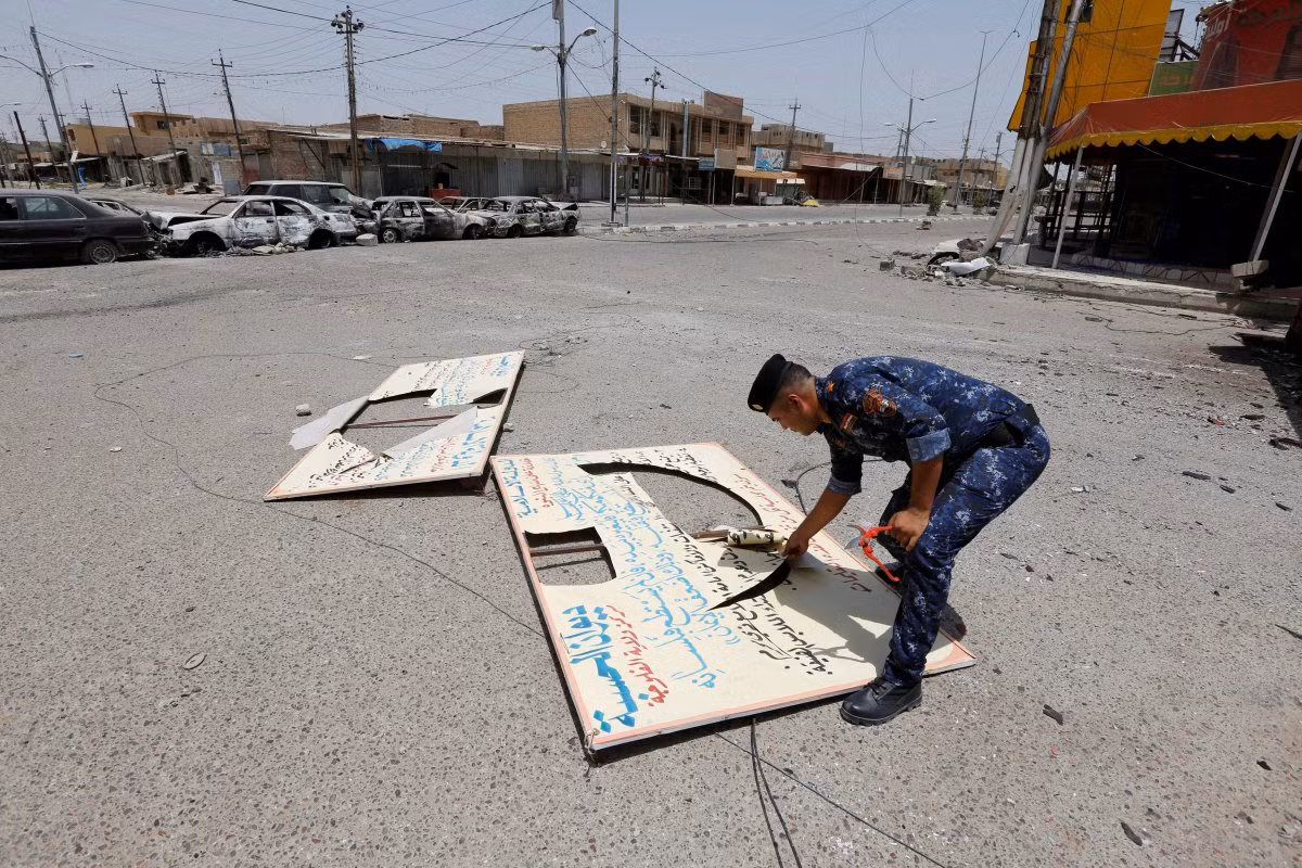 Một tấm biển ghi các quy định hà khắc của IS rơi ngoài đường. Ảnh BI