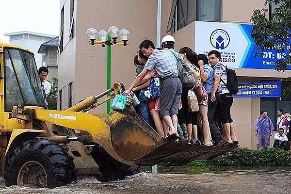 Người dân phải sử dụng máy xúc, xe tải quân sự để có thể di chuyển qua chỗ ngập. Ảnh: Giao thông.