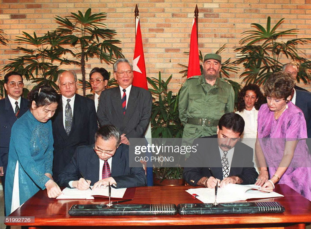 Bộ trưởng Ngoại giao Việt Nam Nguyễn Mạnh Cầm ký văn kiện hợp tác kinh tế với người đồng cấp Cuba, Chủ tịch nước Lê Đức Anh và nhà lãnh đạo Cuba Fidel Castro đứng phía sau, Havana ngày 12/10/1995.