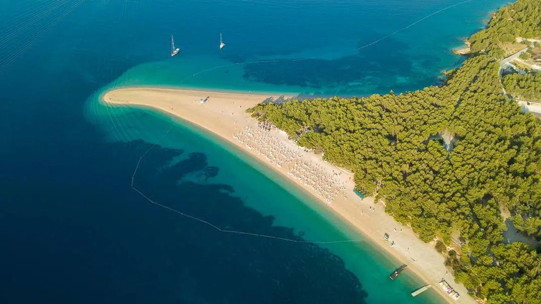 Nước biển ở đây trong vắt như pha lê, phía trên bờ là rừng thông bạt ngàn do chính tay người dân địa phương trồng với mục đích tạo bóng mát