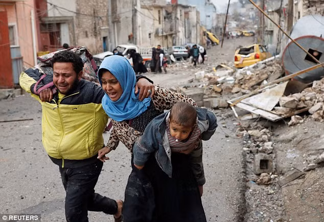 Cảnh hai vợ chồng cùng con nhỏ tháo chạy ở Mosul đã lọt vào máy ảnh của phóng viên tác nghiệp. Ảnh Daily Mail
