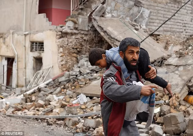 Người đàn ông “vác” theo cậu con trai trên vai trong hành trình chạy khỏi tây Mosul. Ảnh Daily Mail