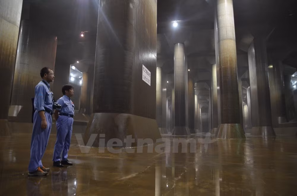 Nhân viên đi thị sát tại bể điều hòa lượng nước. (Ảnh: Nguyễn Tuyến-Thành Hữu/Vietnam+)