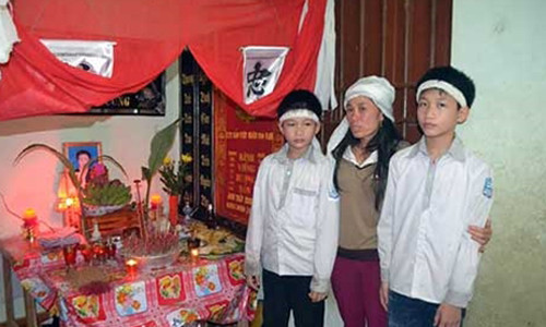 Vợ anh Trinh bên bàn thờ của nạn nhân xấu số.