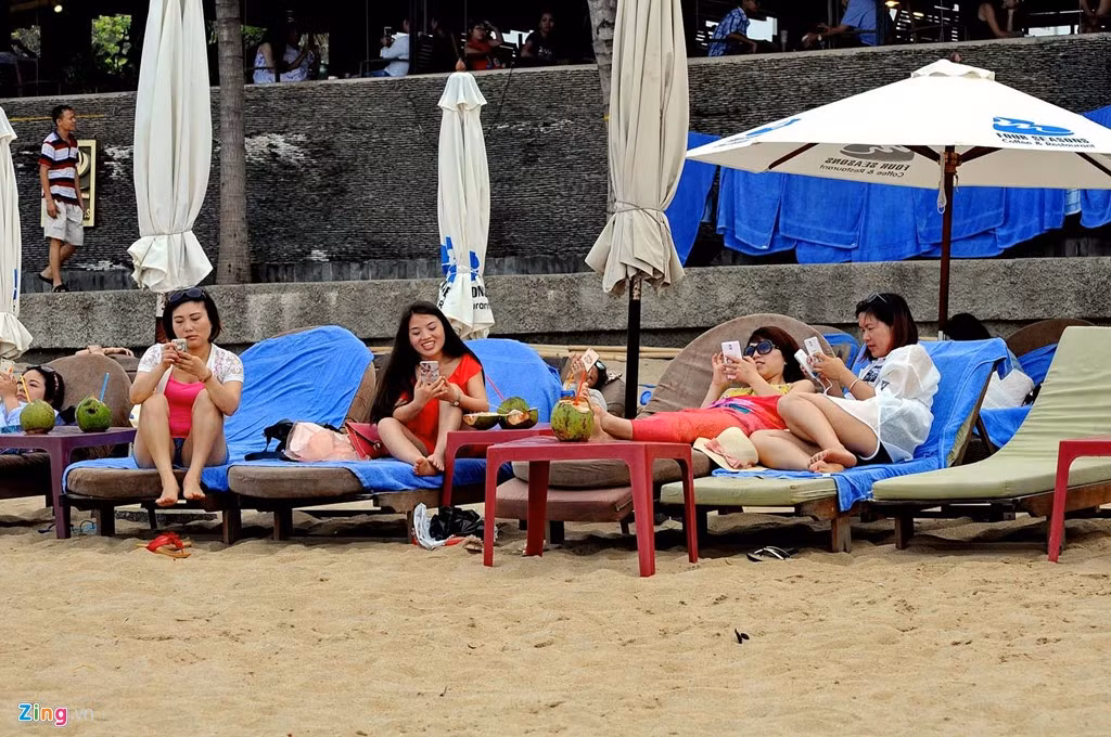 Một số cô gái đến từ quốc gia đông dân nhất thế giới không nhúng người xuống nước biển mà nằm ghế bố của khách sạn lướt Internet cùng nhau.