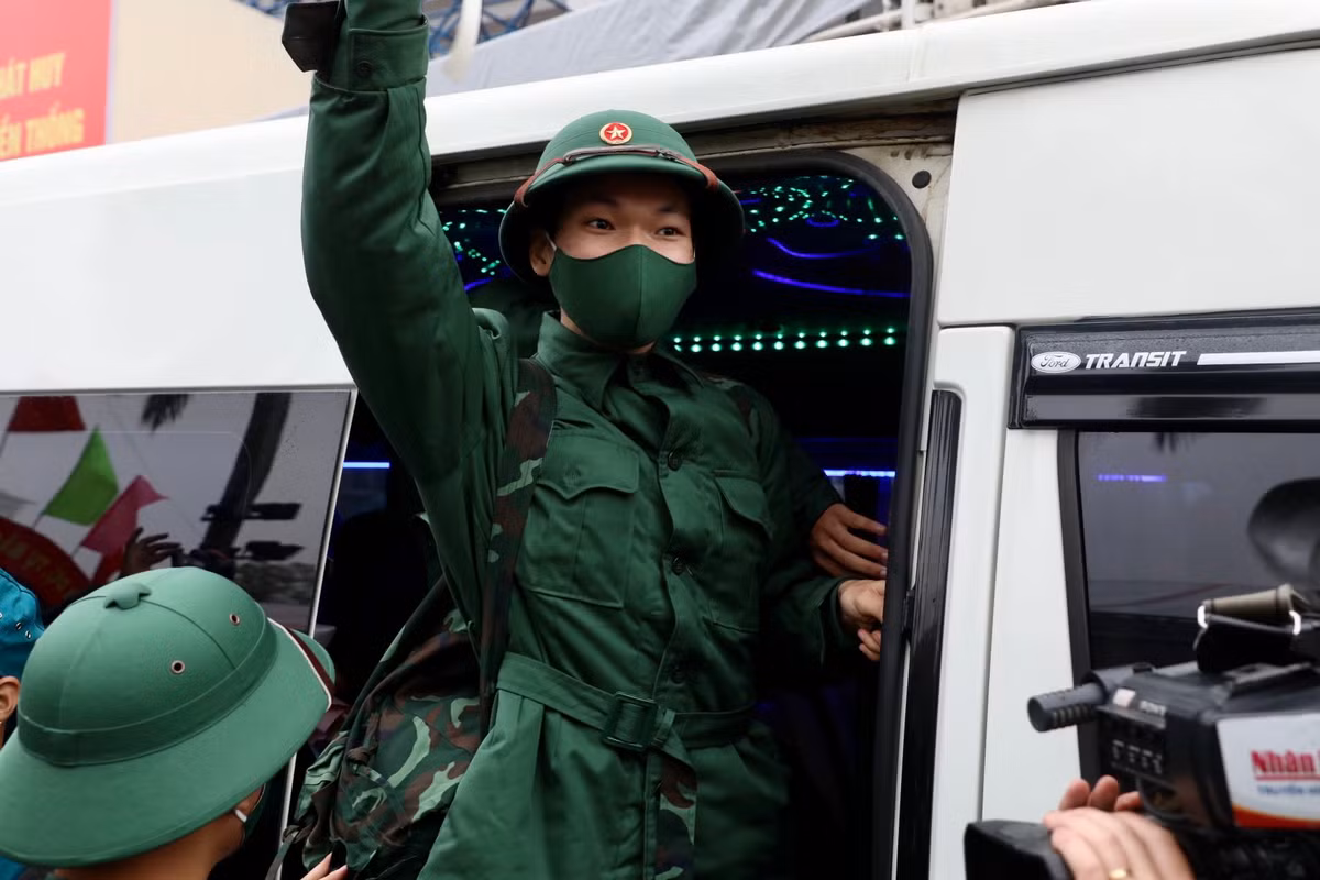 Các tân binh vẫy tay chào người thân lên đường nhập ngũ.