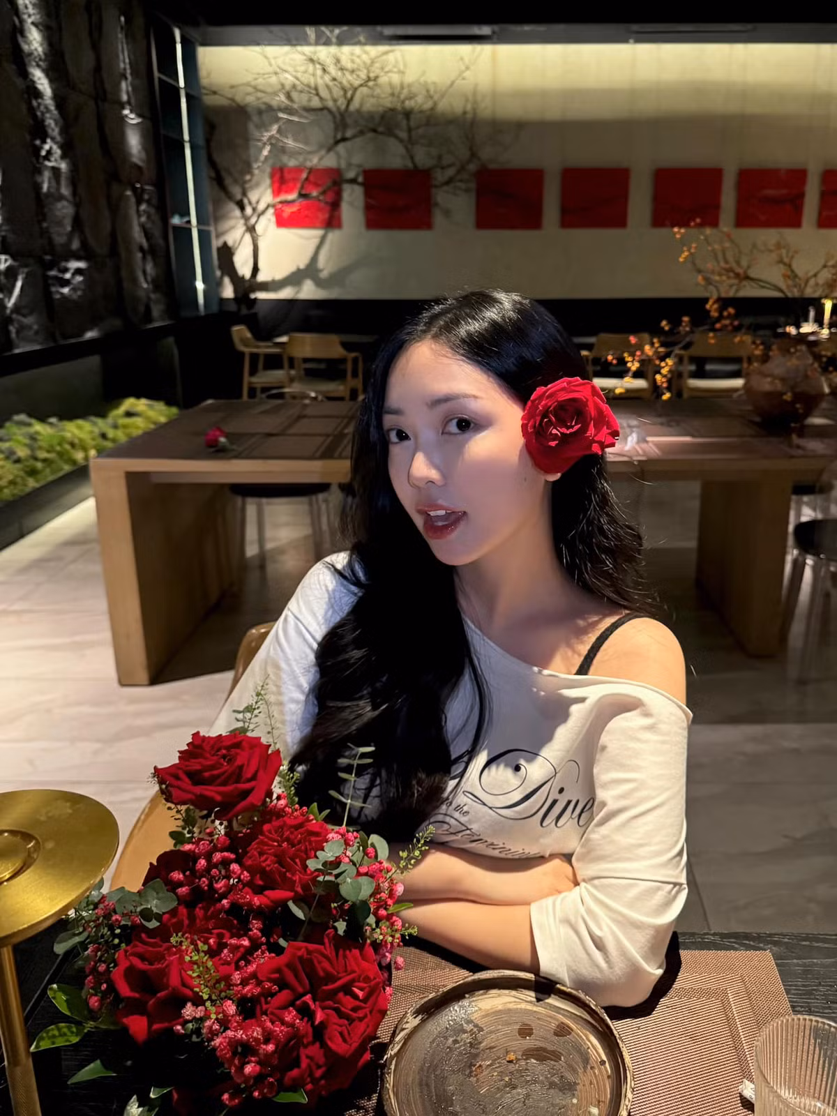 Nàng WAGs diện mẫu áo thun chất liệu mỏng manh, form dáng trễ nải để lộ phần dây của mẫu nội y đen. Thiết kế này giúp vợ Hà Đức Chinh khoe khéo bờ vai nuột nà cùng phần xương quai xanh sắc nét.