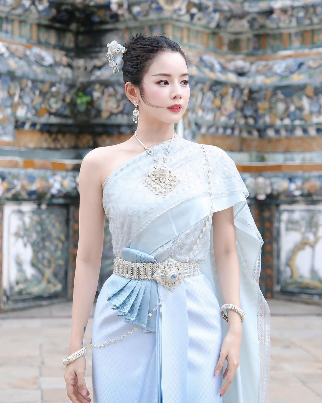 Cô nàng diện lên mình trang phục truyền thống của phụ nữ Thái Lan màu xanh nhạt, tôn lên làn da trắng sứ.