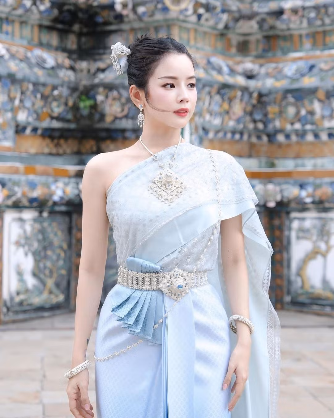 Cô nàng diện lên mình trang phục truyền thống của phụ nữ Thái Lan màu xanh nhạt, tôn lên làn da trắng sứ.