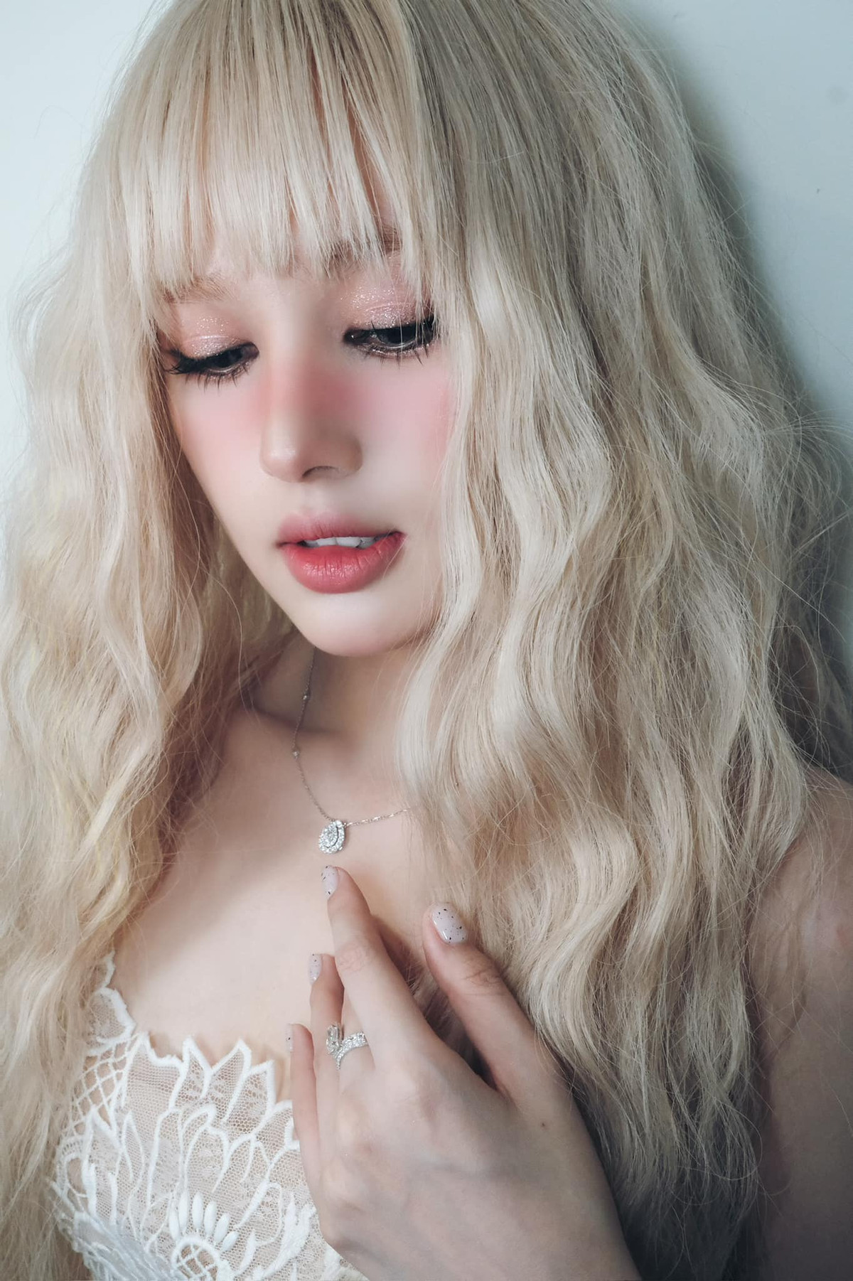 Xoài Non lựa chọn mái tóc dài màu bạch kim được uốn sóng tựa như nữ thần.