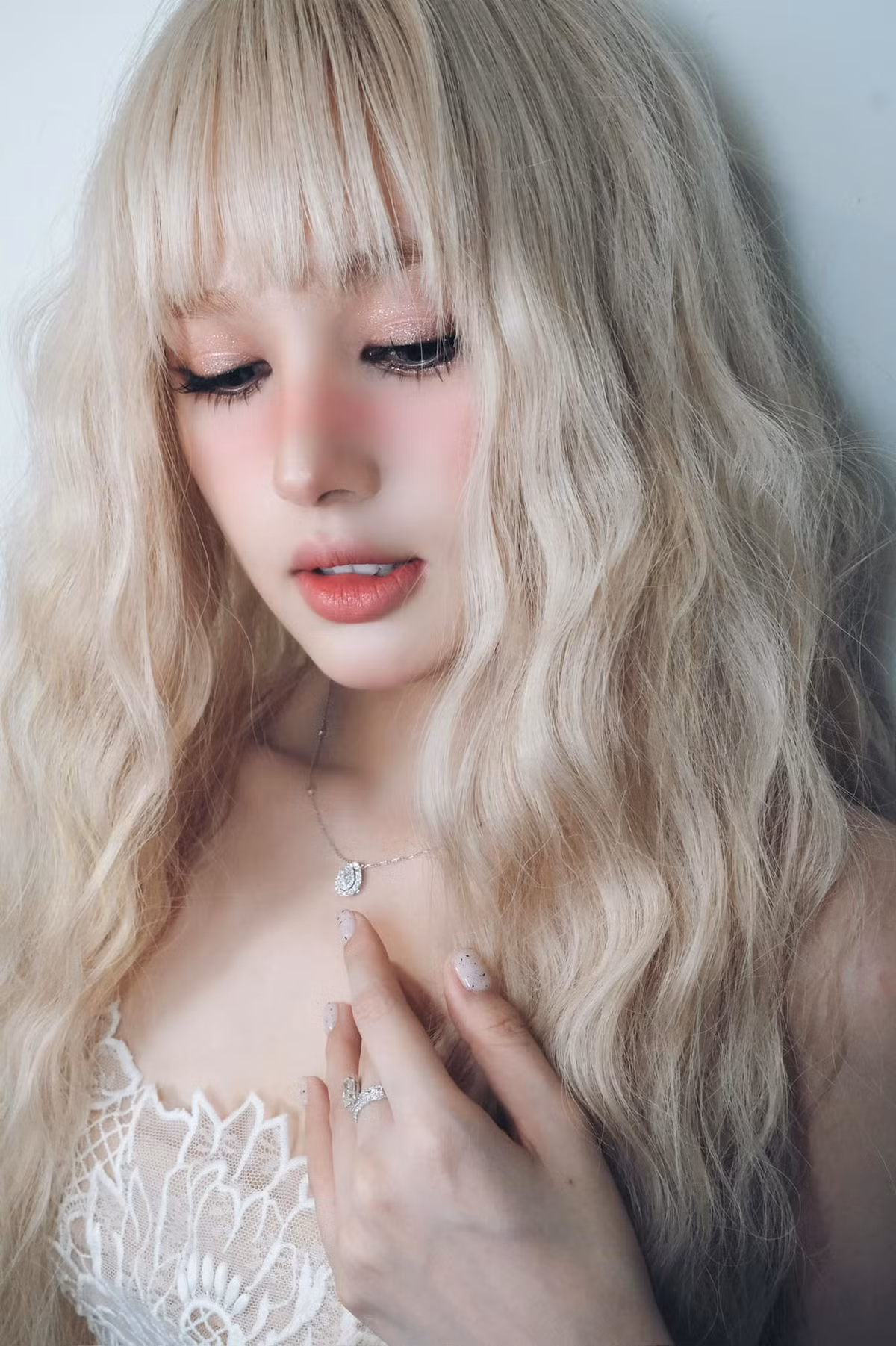 Xoài Non lựa chọn mái tóc dài màu bạch kim được uốn sóng tựa như nữ thần.