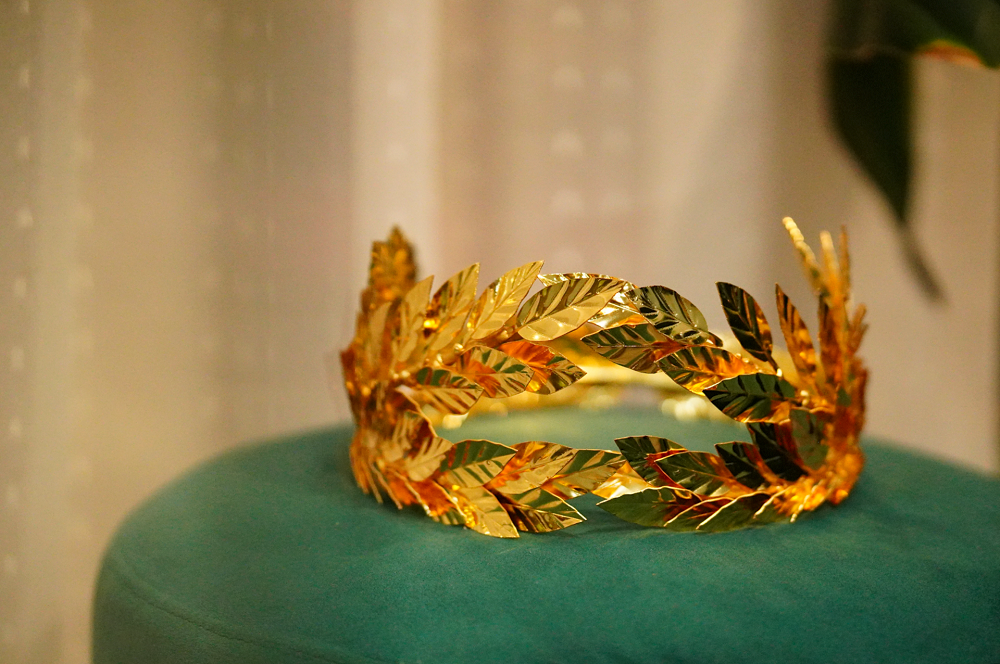 Chiếc vòng nguyệt quế làm từ đồng thau và mạ vàng 18K, không có điểm đầu cũng không có điểm kết thúc, tượng trưng cho tri thức là vô hạn.