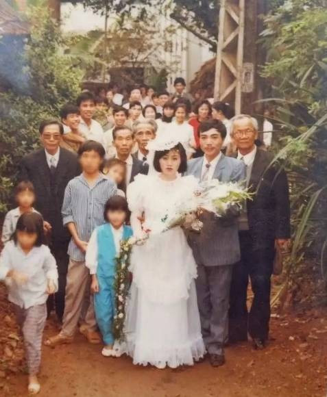 Khung cảnh rước dâu chú rể cô dâu cùng người lớn trong họ đi trước, dân làng và bạn bè theo sau.