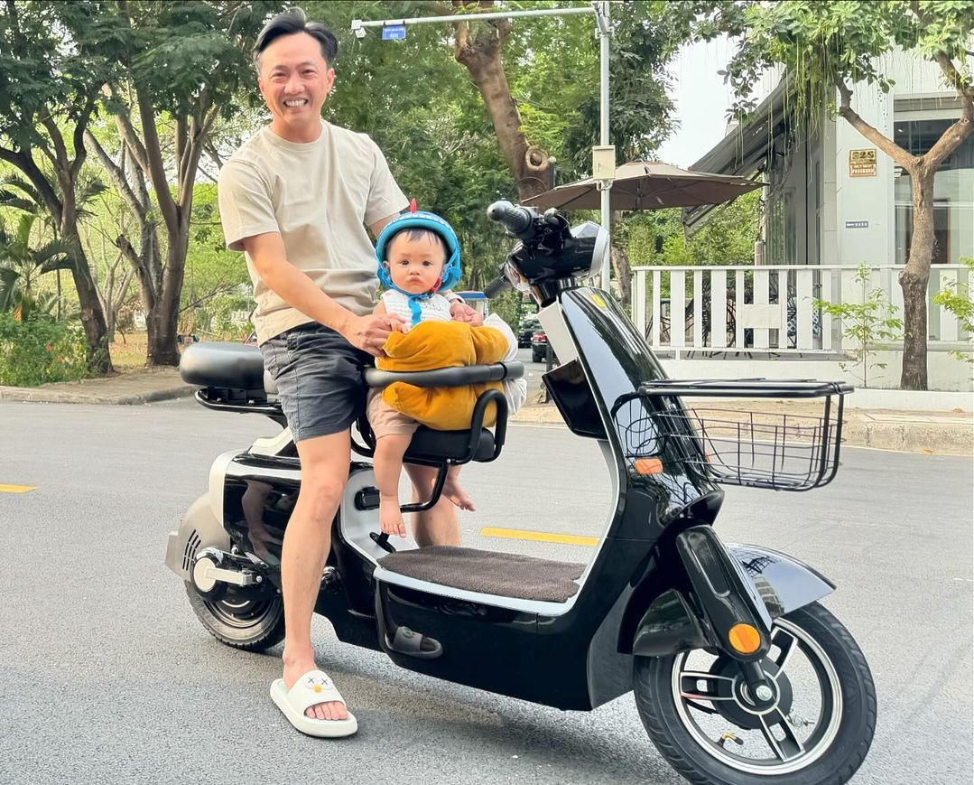 Cường Đôla khoe ảnh đưa con trai đi dạo phố. Bé Sutin trông đáng yêu khi được bố mẹ sắm chiếc mũ bảo hiểm hình khủng long để giữ an toàn. (Ảnh: FBNV)