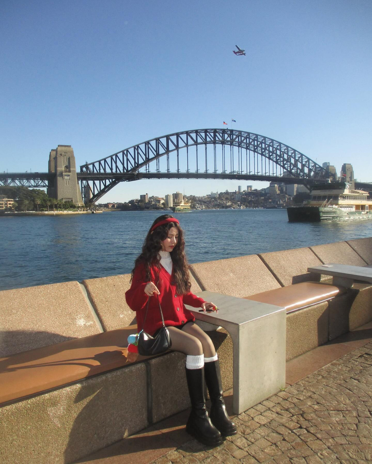 Hạt Dẻ lựa chọn chiếc áo len đỏ, kết hợp cùng chân váy ngắm và đôi boot cao cổ vừa năng động nhưng cũng rất thời trang.