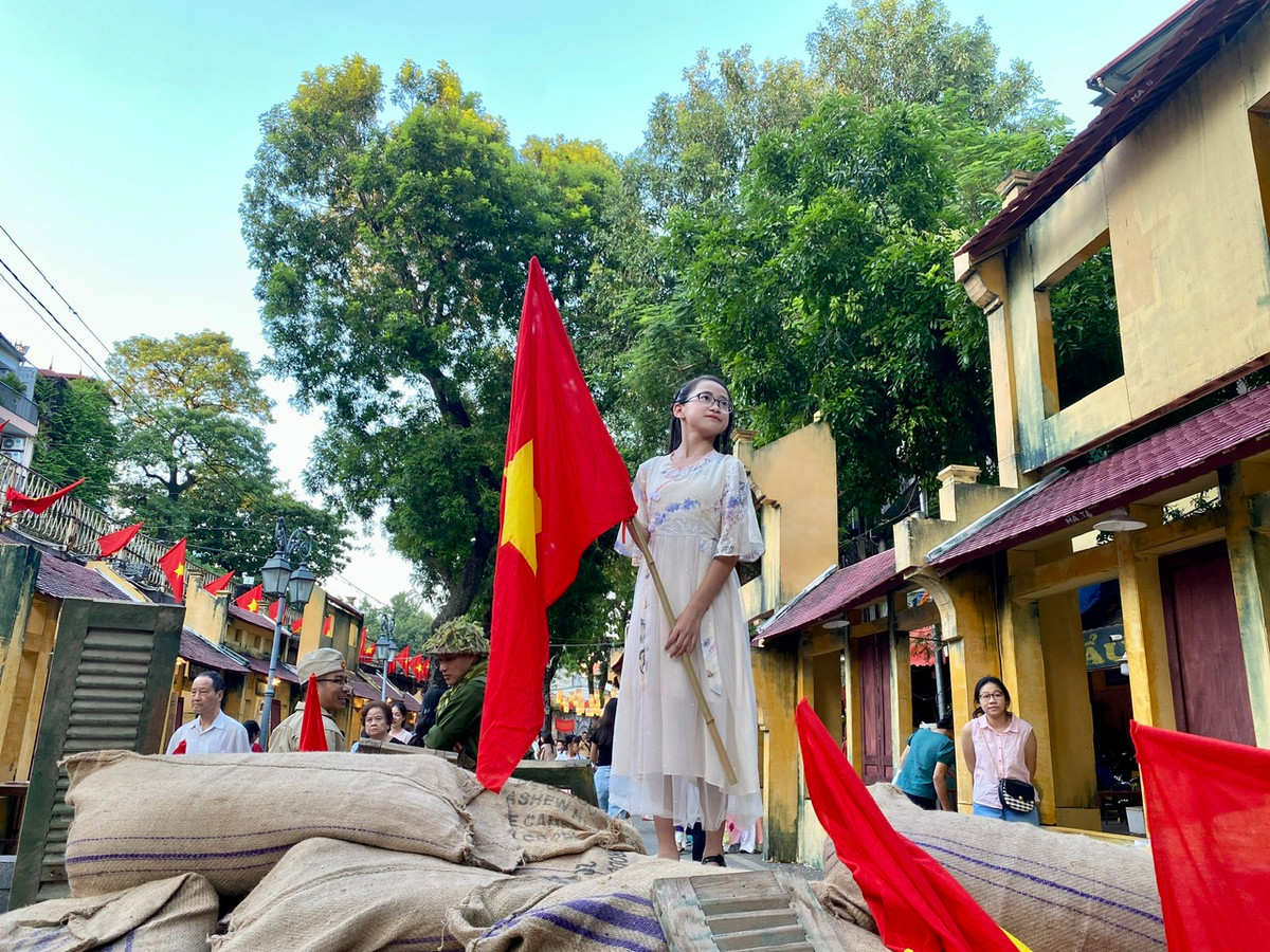 Các em nhỏ hào hứng cầm cờ Tổ quốc để được bố mẹ chụp cho những tấm ảnh thật đẹp.