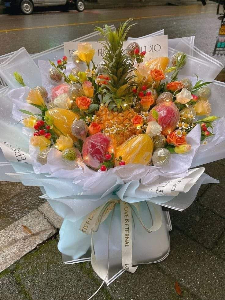 Điểm nhấn của bó hoa rực rỡ này chính là quả dứa làm vedette.